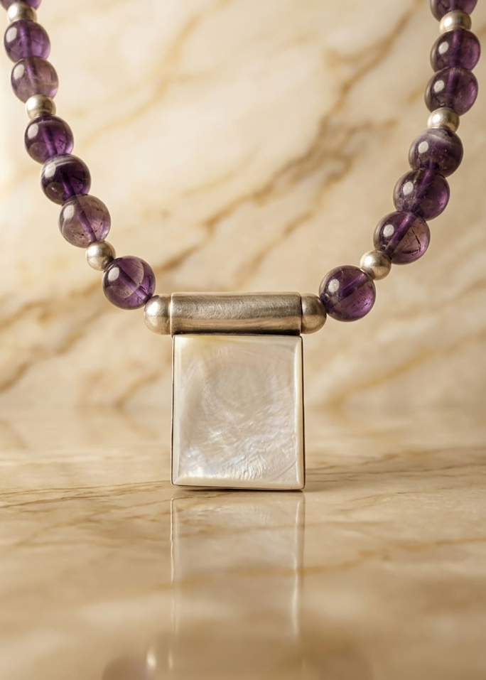 Colgante rectangular de nácar natural enmarcado en plata sobre collar de amatistas