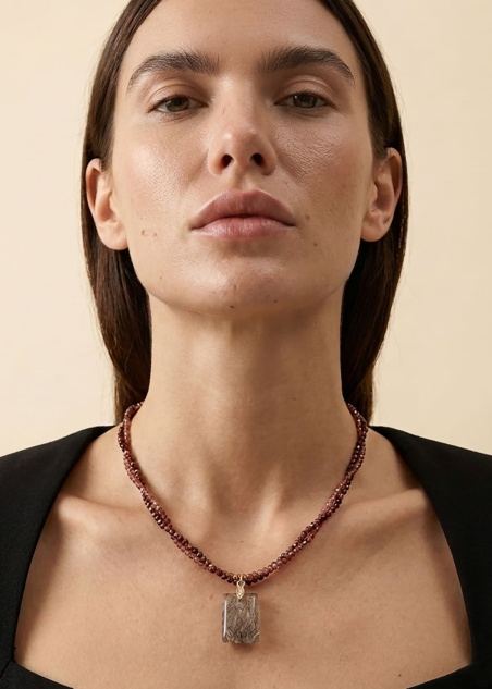 Modelo con collar Brumel con granates naturales y colgante de cuarzo rutilado